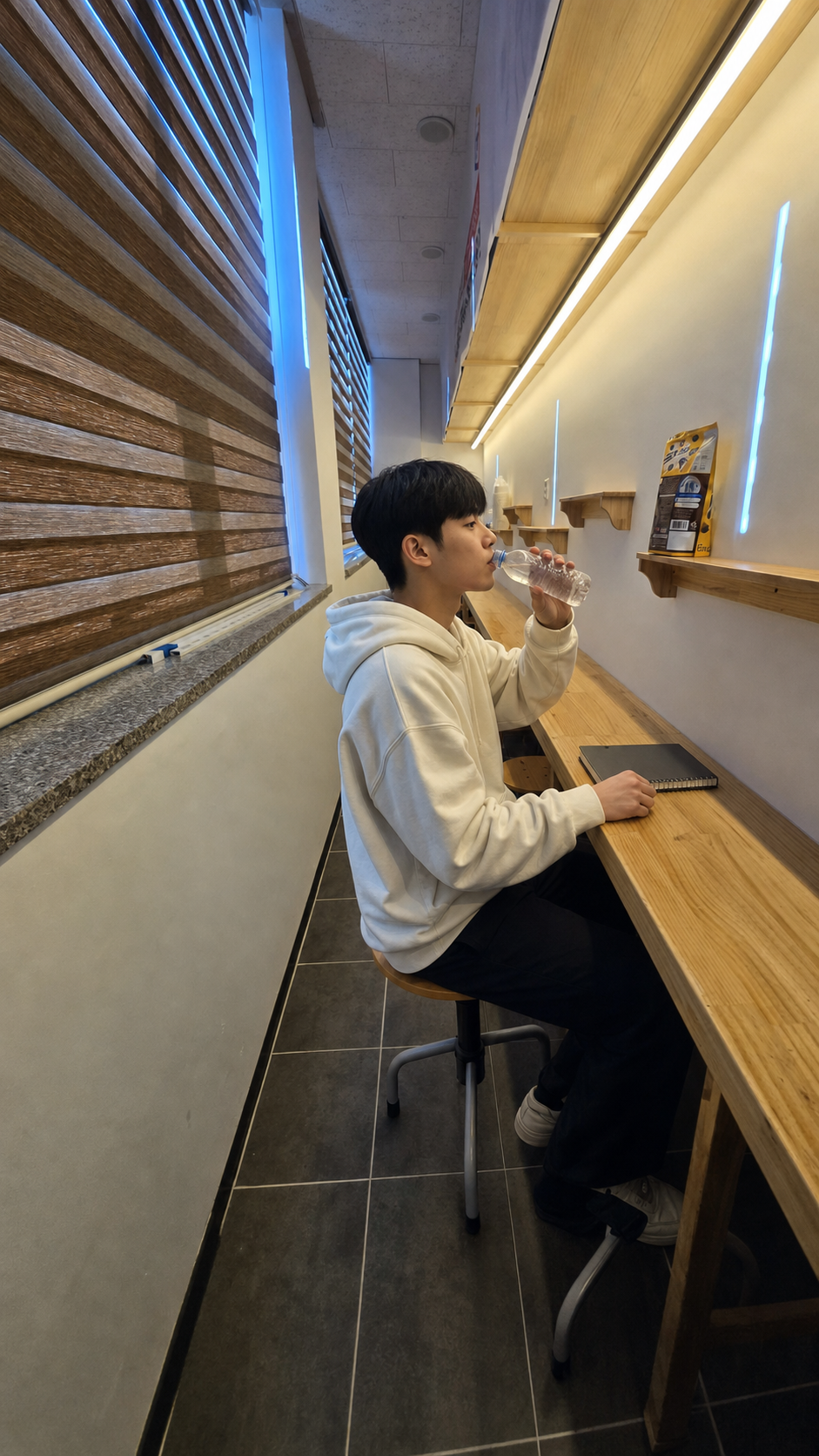 나다올케어 실제 휴게실에서 물을 마시며 짧게 쉬는 주말 사복 차림의 가상 고2 학생 민수